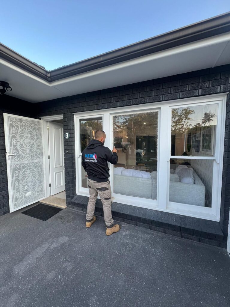 nsw glass masters tradesman standing outside a house fixing a broken window