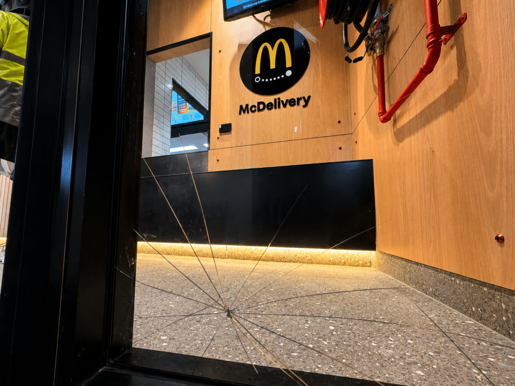 Broken shopfront glass before replacement at a Sydney business
