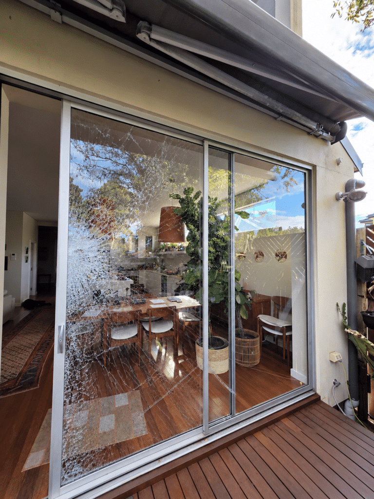 Broken residential sliding door glass requiring repair in Sydney